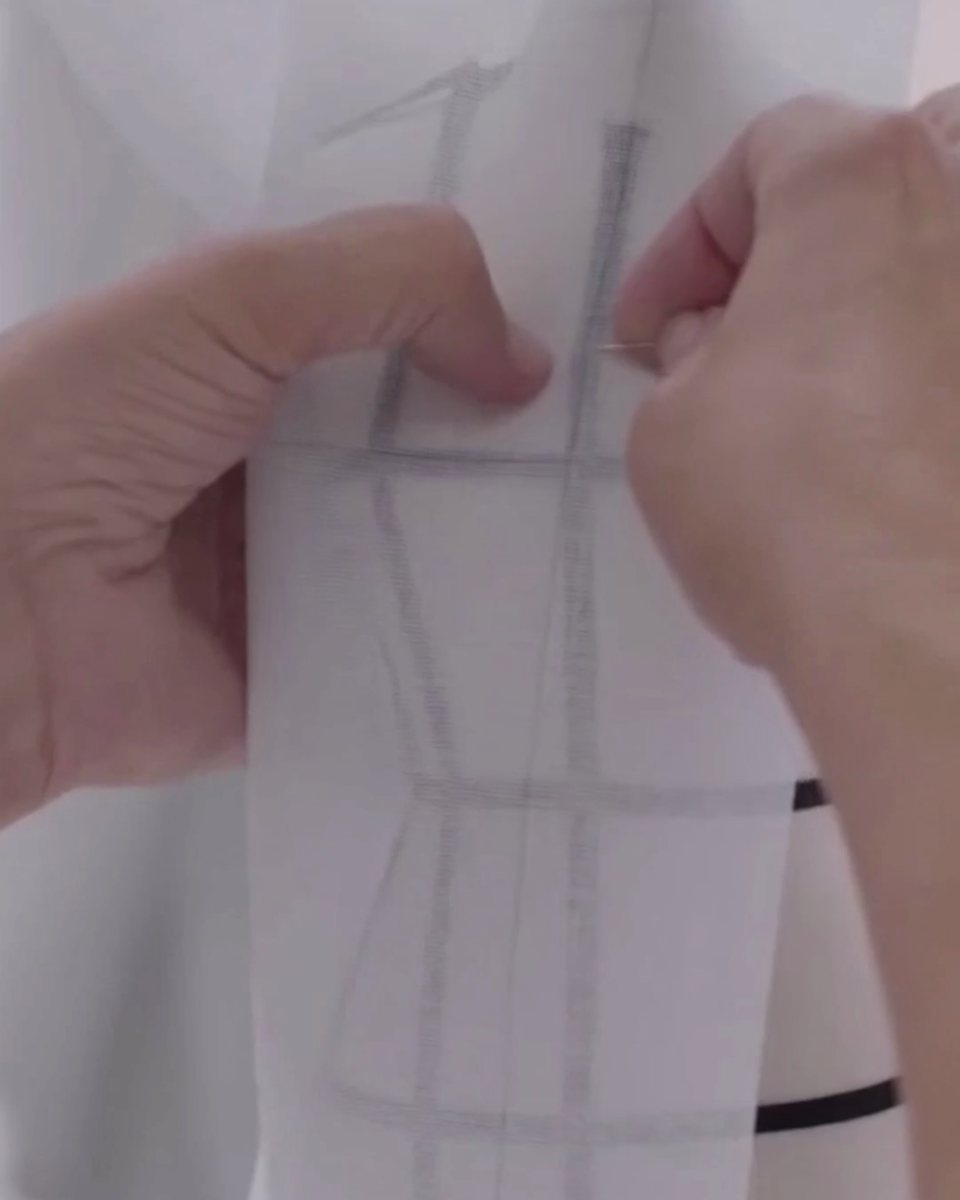 ボディに合わせてパターン用紙を当てる手元